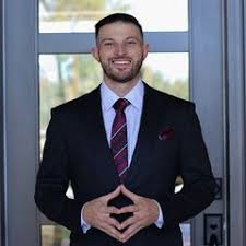 Christopher Kortright standing in a suit at a doorway